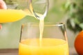 Pouring fresh orange juice into glass, closeup Royalty Free Stock Photo