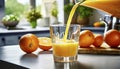 Pouring fresh orange juice into a glass with fresh fruits in background Royalty Free Stock Photo