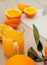 Pouring fresh orange juice. Squeezed orange parts on wooden board. Close up glass of fresh orange juice. Healthy and Royalty Free Stock Photo