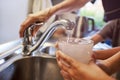 Close up of woman and children hands, pouring glass of fresh water from tap in kitchen Royalty Free Stock Photo