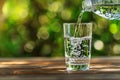 Pouring fresh water into a glass on a sunny day Royalty Free Stock Photo