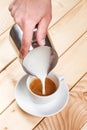 Pouring frothed milk into a cup of coffee Royalty Free Stock Photo