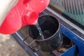 Pouring fuel with funnel in a car gas tank from red can Royalty Free Stock Photo