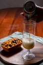 Pouring of German wheat beer is glass and bowl with party mix nuts Royalty Free Stock Photo