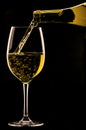 Pouring a glass of wine on black background. Royalty Free Stock Photo