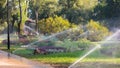 Pouring grass and flowers by irrigation water system.