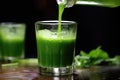 pouring green juice shot in slow motion