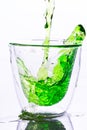 Pouring green water in to clear glass