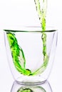 Pouring green water in to clear glass Royalty Free Stock Photo