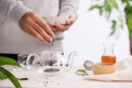 Pouring healthy tea. Hot tea on a glass teapot on a wooden table