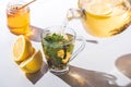 pouring healthy tea with lemon and mint from teapot into cup Royalty Free Stock Photo