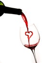 Pouring a heart of red wine into a glass Royalty Free Stock Photo