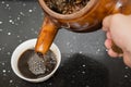 Pouring herbal tea from an enamel pot with herb to bowl Royalty Free Stock Photo