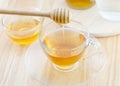 Pouring honey into cup of tea on wooden table Royalty Free Stock Photo