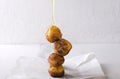 Pouring honey on the donut holes cooked with cheese.Delicious deep fried dough balls with cheese and honey