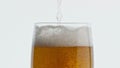 Pouring hoppy liquid glass closeup. Unfiltered barley beer stream filling goblet