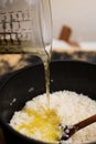 Pouring hot chicken stock in a risotto dish