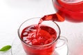 Pouring hot red tea into glass cup on table Royalty Free Stock Photo