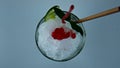 Pouring iced strawberry cocktail jam in glass closeup. Refreshing summer mojito