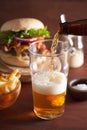 Pouring india pale ale beer into pint glass and fast food Royalty Free Stock Photo