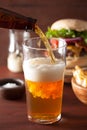 Pouring india pale ale beer into pint glass and fast food Royalty Free Stock Photo