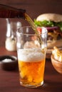 Pouring india pale ale beer into pint glass and fastfood Royalty Free Stock Photo