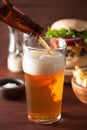 Pouring india pale ale beer into pint glass and fastfood Royalty Free Stock Photo