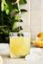 Pouring Italian typical digestive limoncello in a glass with kitchen background