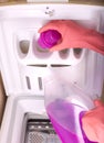 Pouring laundry detergent into washing machine Royalty Free Stock Photo