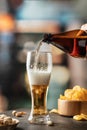 Pouring light foamy beer into glass in bar background. Traditional drinks, Oktoberfest concept