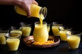 pouring mango lassi from a jug into glasses