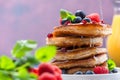 Pouring Maple Syrup on American Pancakes Topped with Fresh Fruits. Shrove Tuesday