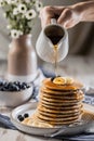 Pouring maple syrup on homemade banana pancakes with blueberry, easy recipes homemade cooking