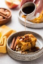 Pouring maple syrup onto pumpkin cake slice