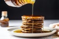 pouring maple syrup onto a stack of vegan pancakes