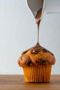 pouring melted chocolate over muffin