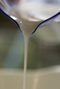 Pouring Milk from a Blueish Measuring Cup