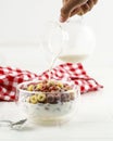 Pouring Milk into the Bowl with Froot Loops Colorful Cereal. Kids Breakfast Concept Royalty Free Stock Photo