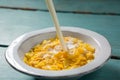 Pouring milk into bowl of wheaties cereal Royalty Free Stock Photo