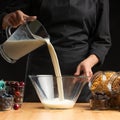 Pouring milk into the breakfast, freezing in motion. Cooking breakfast cereals, granules, breakfast cereals, cereals, berries of Royalty Free Stock Photo