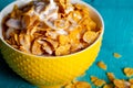 Pouring milk into the ceramic bowl of corn flakes Royalty Free Stock Photo