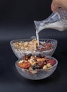 Pouring milk into the Cereal in Glass bowl served with Tasty Gadola in dark background Royalty Free Stock Photo