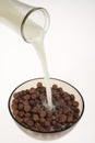 Pouring milk into chocolate cereal bowl Royalty Free Stock Photo