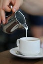 Pouring Milk into a Cup of Energizing Morning Coffee Royalty Free Stock Photo