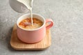 Pouring milk into cup of black tea Royalty Free Stock Photo