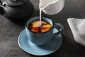 Pouring milk into cup of black tea Royalty Free Stock Photo