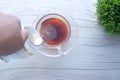 Pouring milk into cup of black tea on table, Royalty Free Stock Photo