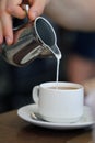 Pouring Milk into a Cup of Energizing Morning Coffee Royalty Free Stock Photo