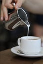 Pouring Milk into a Cup of Energizing Morning Coffee Royalty Free Stock Photo