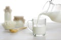 Pouring milk into the glass on dairy products background Royalty Free Stock Photo